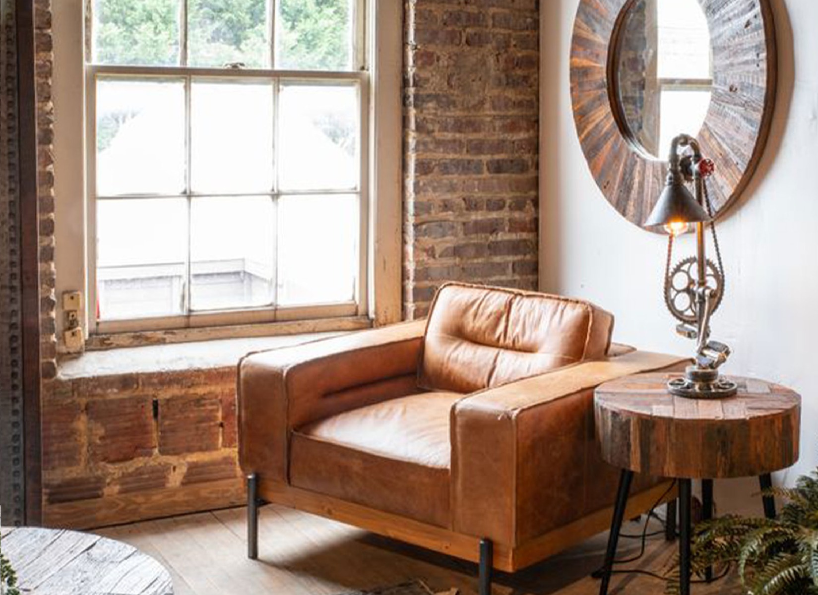 High Point Showroom showcasing our Portofino Industrial Accent Chair in Cocoa Brown Leather and our Jaipur Mirror and Side Table. 